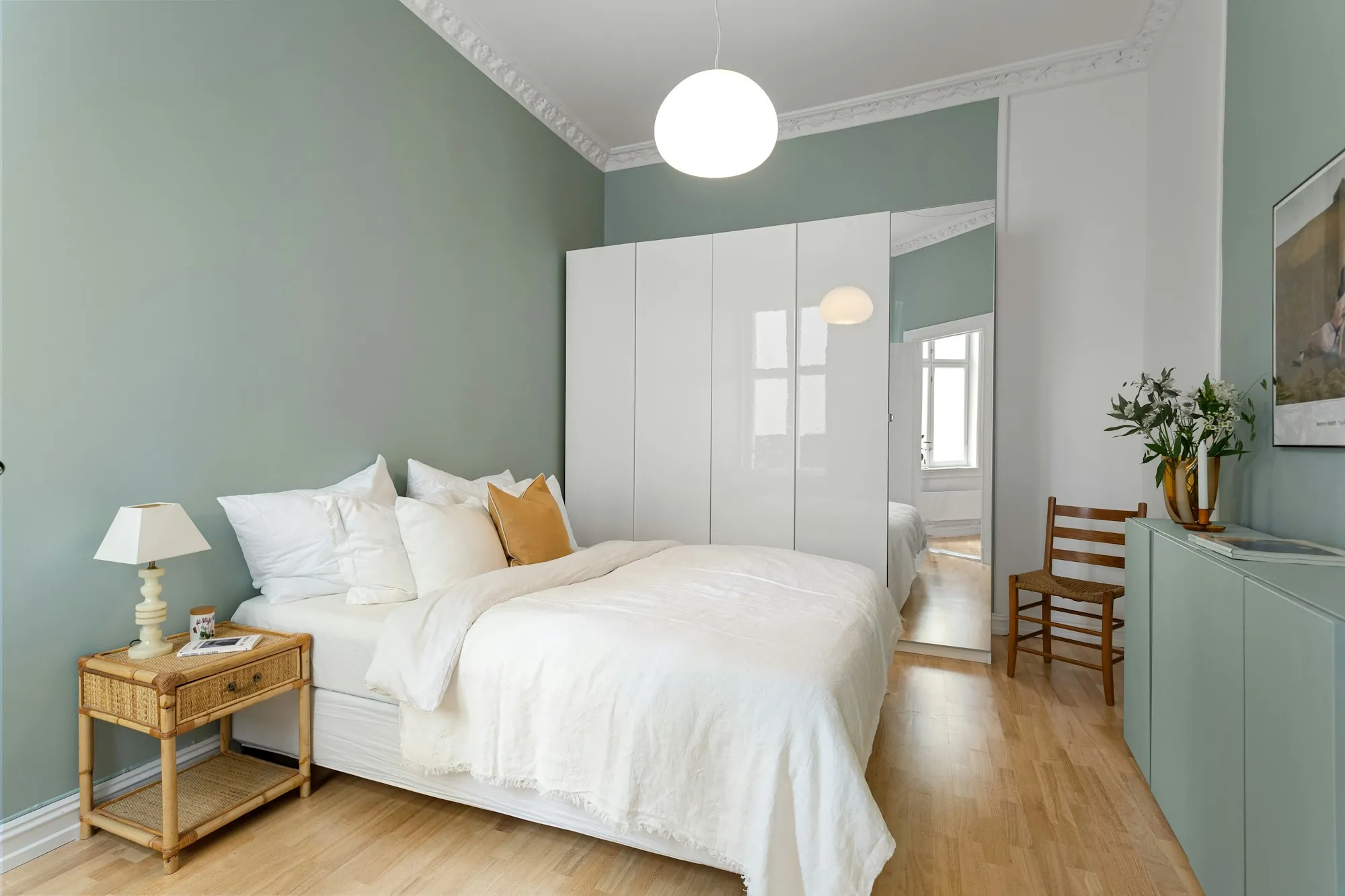 Calm bedroom with white bedding and a wooden nightstand
